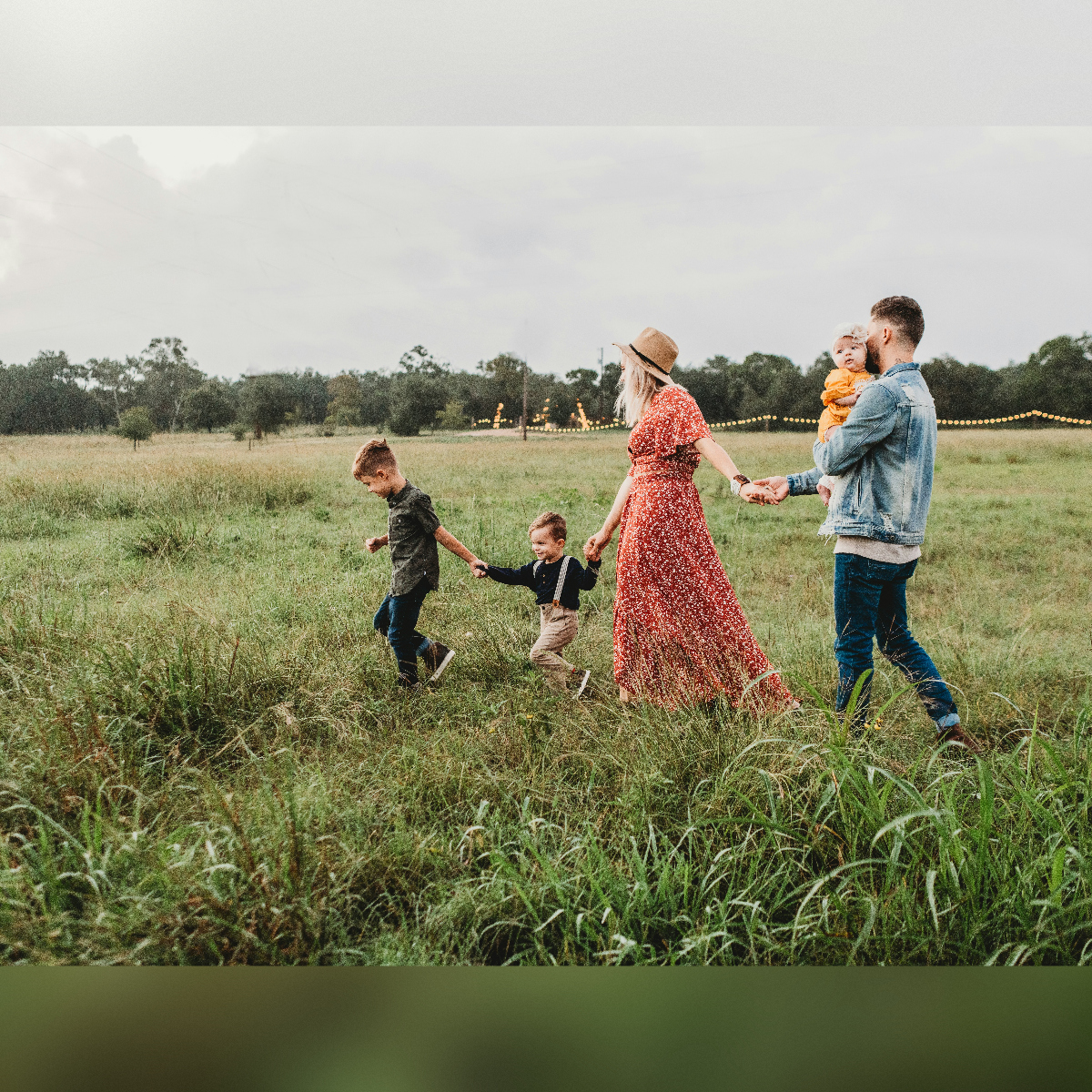 Donna che tiene le mano di un bambino e di un uomo durante il giorno